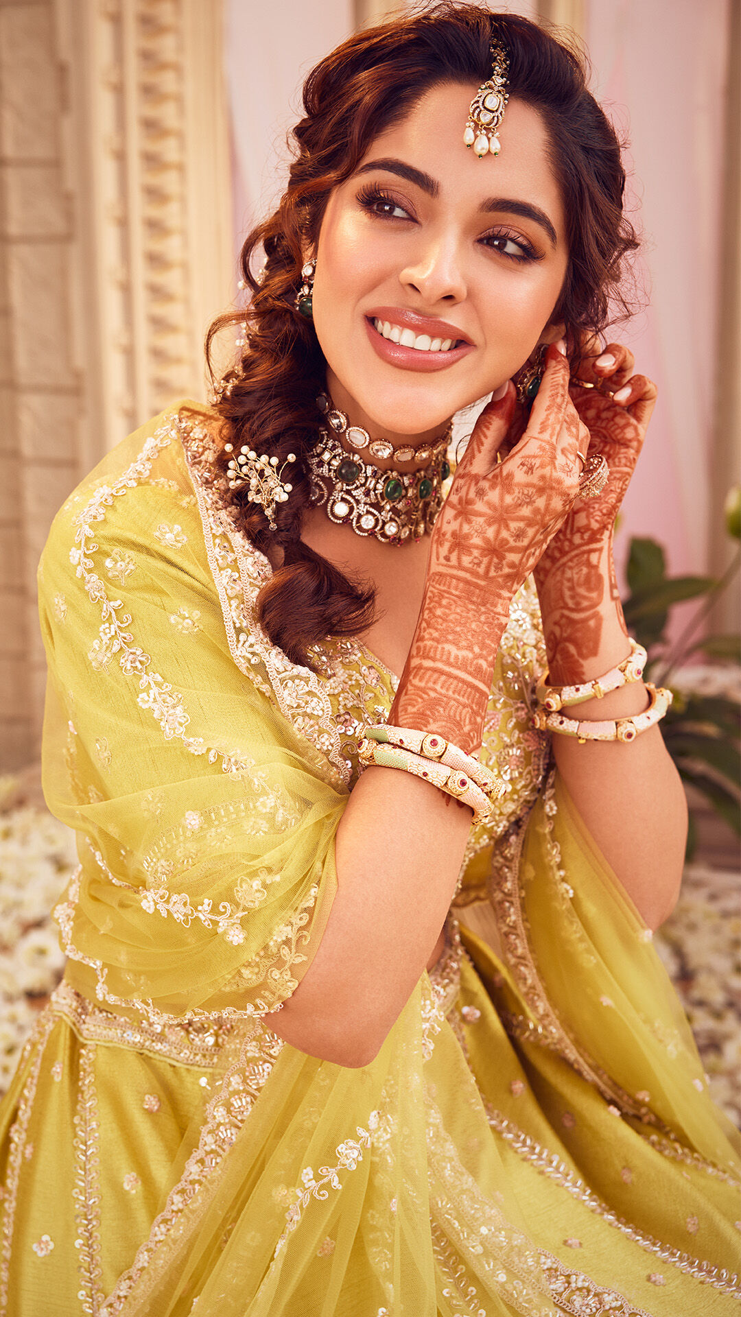 Bride in a vibrant yellow lehenga at her pre-wedding ceremony
